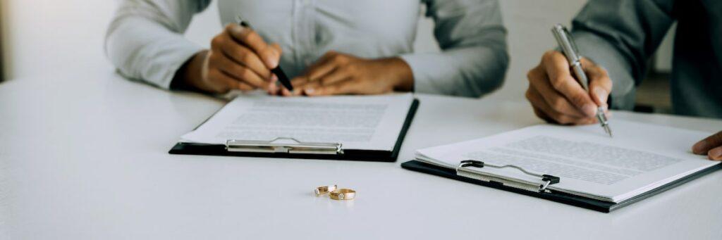 Deux personnes signent des documents de divorce